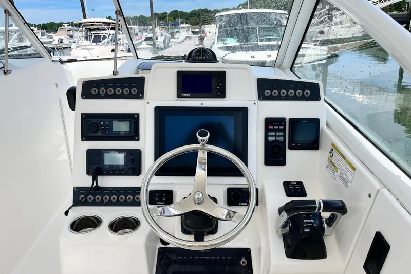 Slide: The Image of Helm of 2014 Edgewater 280CX Crossover boat with modern navigation controls and steering wheel. - 24