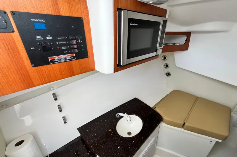 Slide: The Image of 2014 Edgewater 280CX Crossover cabin with microwave, sink, and control panel. - 28