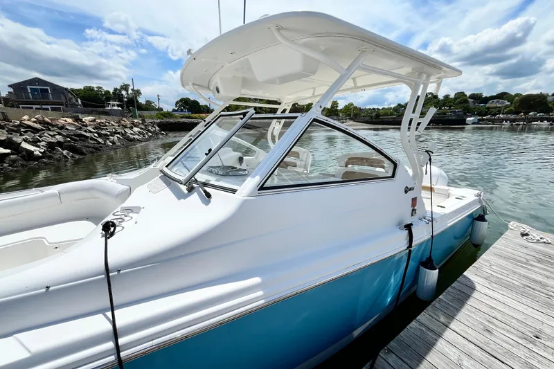 Slide: The Image of 2014 Edgewater 280CX Crossover boat docked by a scenic waterfront. - 6
