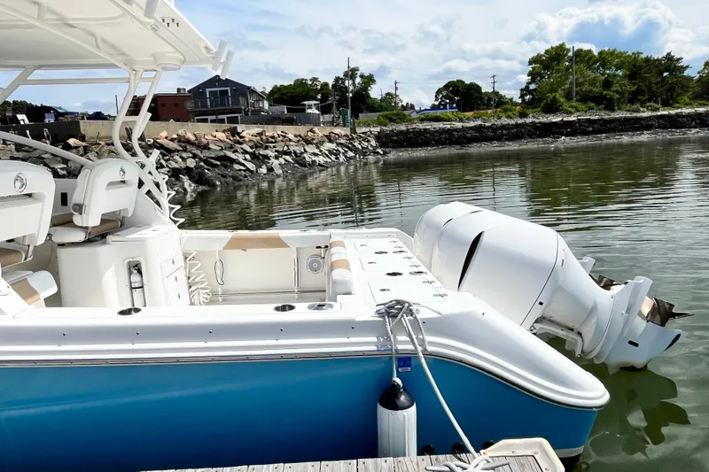 Slide: The Image of 2014 Edgewater 280CX Crossover boat docked by rocky shoreline. - 8