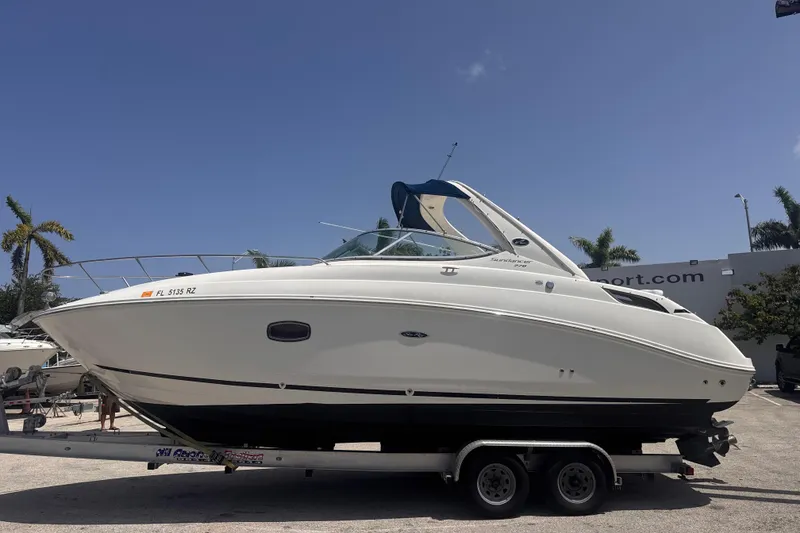 Slide: The Image of 2009 Sea Ray 270 Sundancer boat on trailer under clear blue sky. - 10
