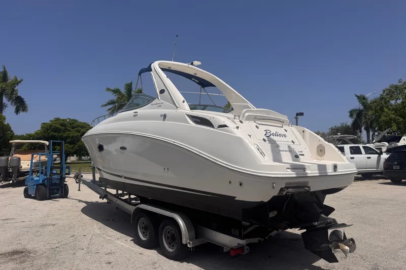 Slide: The Image of 2009 Sea Ray 270 Sundancer boat on trailer, parked outdoors under clear sky. - 9