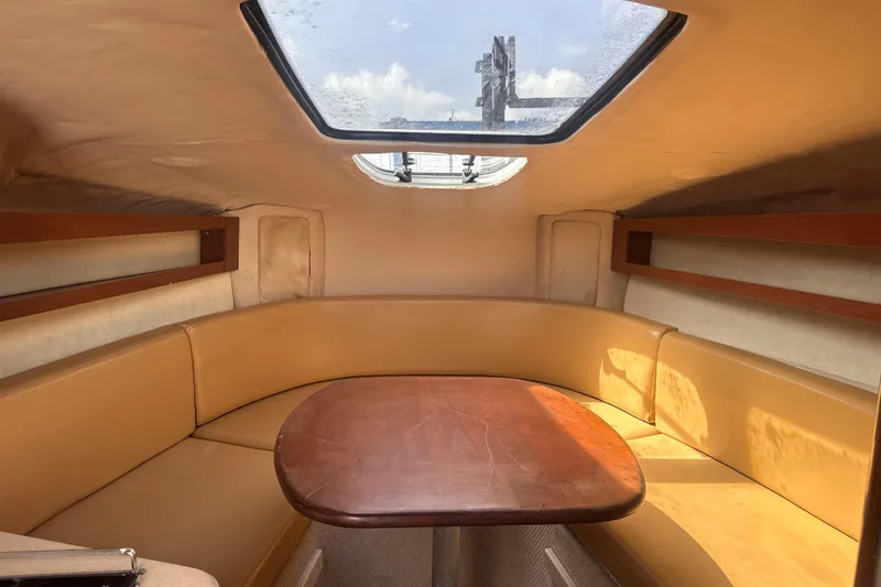 Slide: The Image of Interior of 2009 Sea Ray 270 Sundancer boat with cozy seating and wooden table. - 21