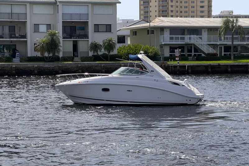 Slide: The Image of 2009 Sea Ray 270 Sundancer cruising on a river near waterfront homes. - 2