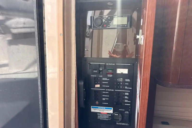 Slide: The Image of Control panel of a 2009 Sea Ray 270 Sundancer boat, featuring various switches and a stereo system. - 26