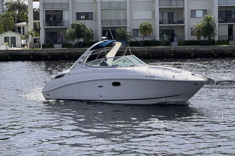 Slide: The Image of 2009 Sea Ray 270 Sundancer cruising on a calm waterway near waterfront buildings. - 4