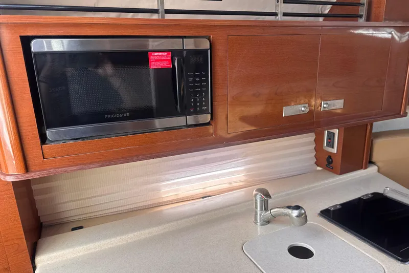 Slide: The Image of Interior of 2009 Sea Ray 270 Sundancer with Frigidaire microwave and wooden cabinetry. - 20