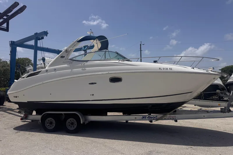 Slide: The Image of 2009 Sea Ray 270 Sundancer boat on trailer under clear blue sky. - 7