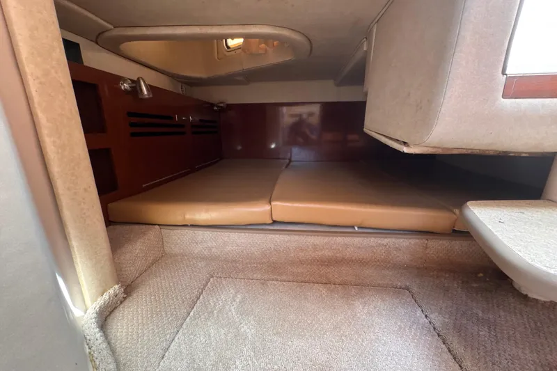 Slide: The Image of 2009 Sea Ray 270 Sundancer cabin interior with beige cushions and wood accents. - 24