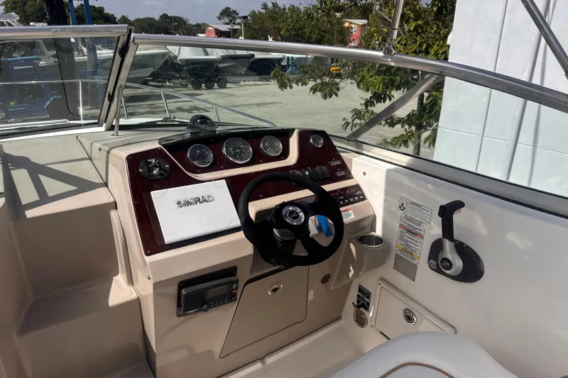 Slide: The Image of 2009 Sea Ray 270 Sundancer helm with steering wheel, gauges, and control panel. - 14