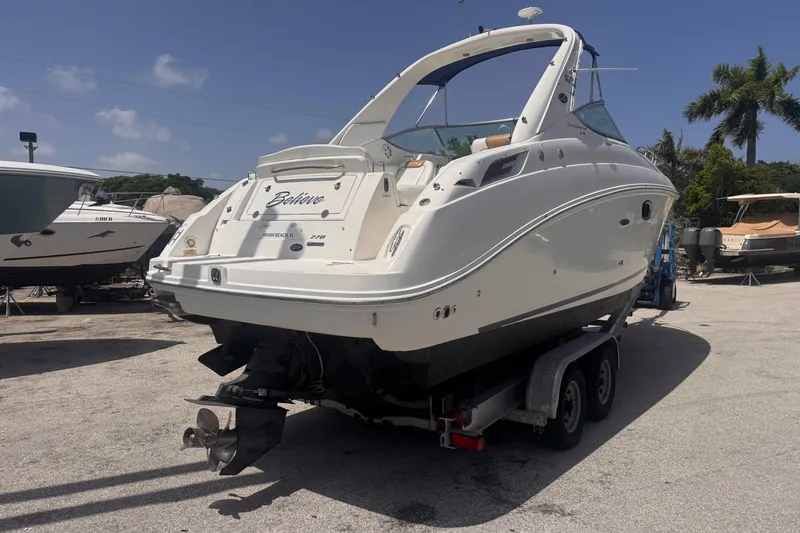 Slide: The Image of 2009 Sea Ray 270 Sundancer boat on trailer, parked outdoors under clear sky. - 8