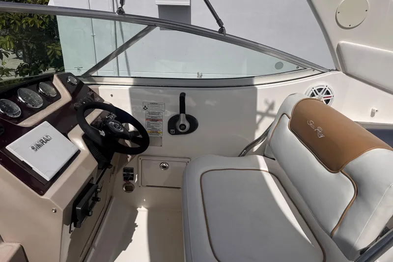 Slide: The Image of 2009 Sea Ray 270 Sundancer cockpit with steering wheel and cushioned seating. - 15