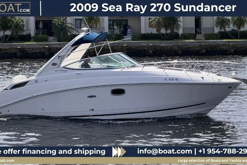 The Image of 2009 Sea Ray 270 Sundancer cruising on water near waterfront buildings. - 1