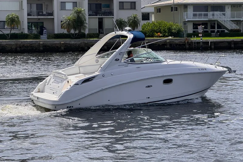 Slide: The Image of 2009 Sea Ray 270 Sundancer cruising on a calm waterway near residential buildings. - 6