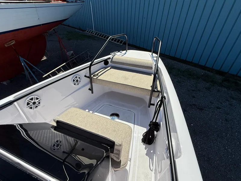 Slide: The Image of The image shows the bow of a 2024 Axopar 22 T-Top boat with seating and railings. - 8