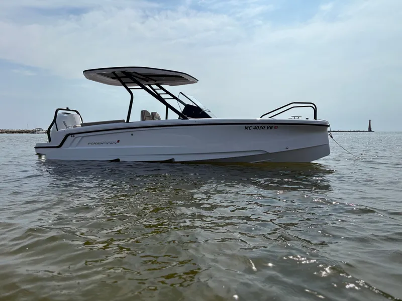 The Image of A 2024 Axopar 22 T-Top boat floats on calm water under a cloudy sky. - 0