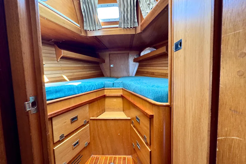 Slide: The Image of 1970 Hincley 38 boat cabin with wooden interior and blue bedding. - 30