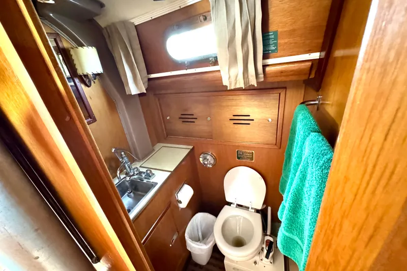 Slide: The Image of 1970 Hincley 38 yacht bathroom with wooden interior, sink, and toilet. - 28