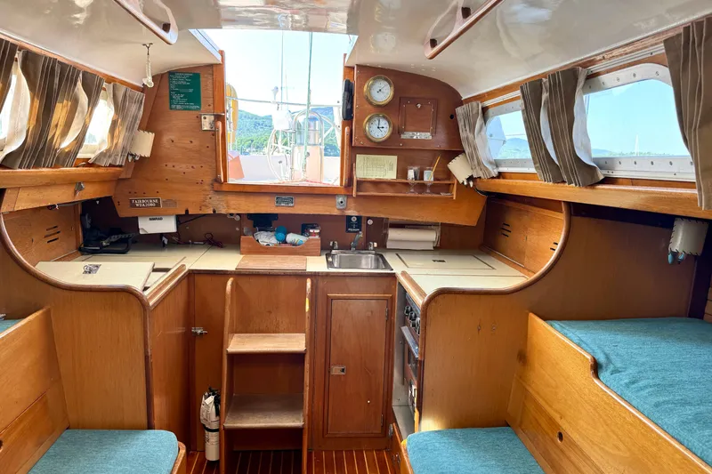 Slide: The Image of Interior of a 1970 Hincley 38 sailboat with wooden cabinetry and nautical decor. - 25