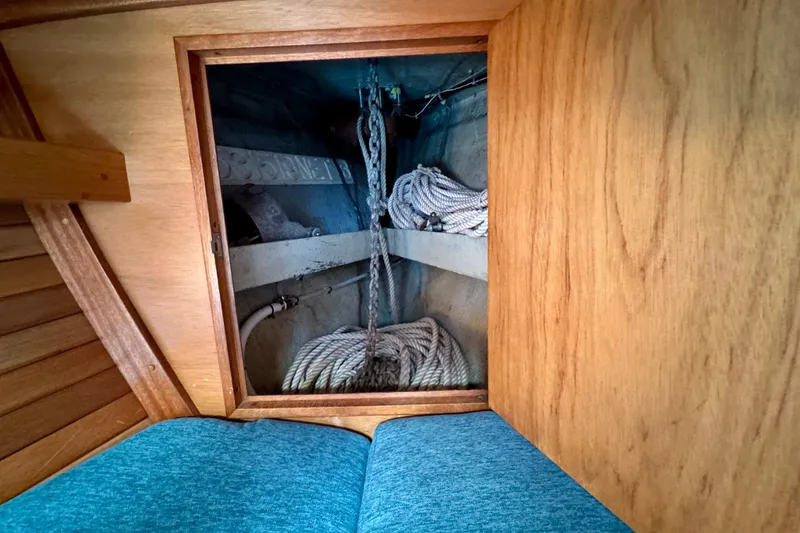 Slide: The Image of Interior view of a 1970 Hincley 38 sailboat showing storage compartment with ropes. - 35