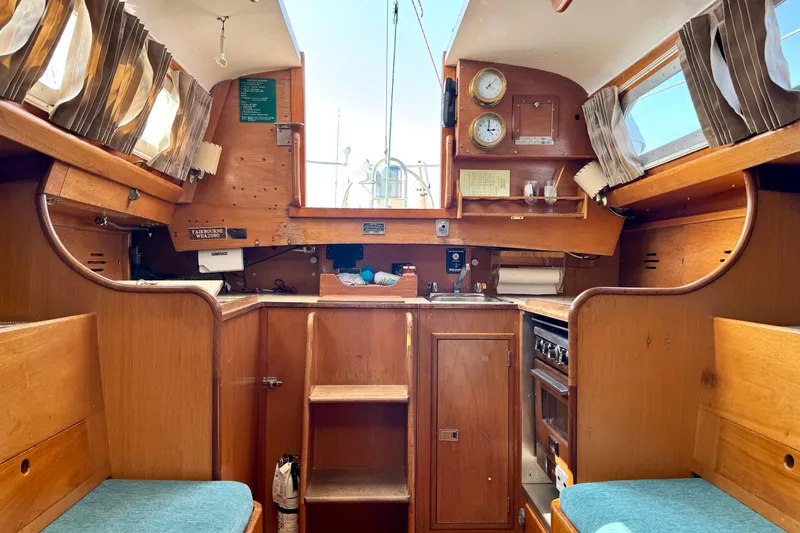 Slide: The Image of Interior of a 1970 Hincley 38 sailboat with wooden cabinetry and nautical instruments. - 22