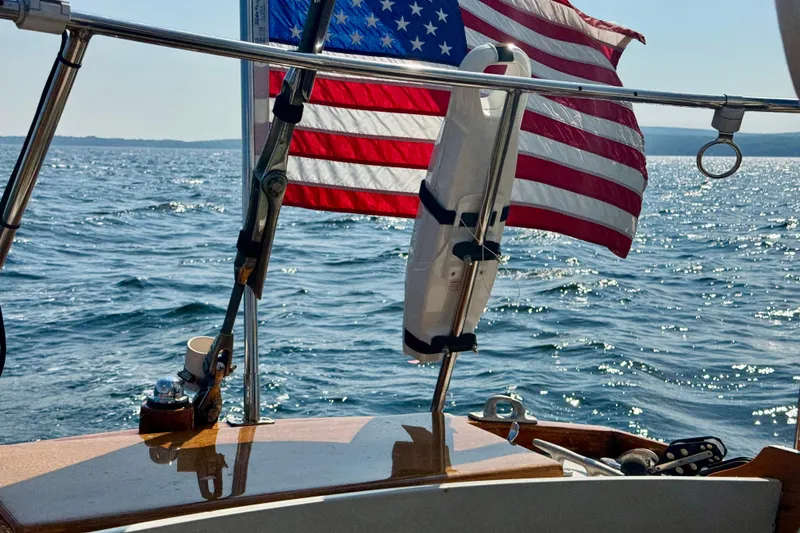 Slide: The Image of Vintage 1970 Hincley 38 sailboat with American flag on open water. - 17