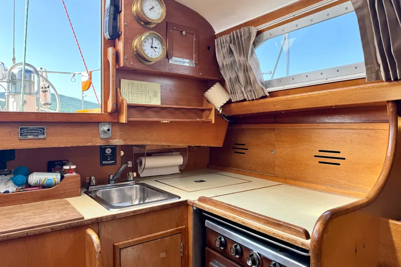 Slide: The Image of Vintage 1970 Hincley 38 yacht kitchen with wooden cabinetry and nautical instruments. - 21