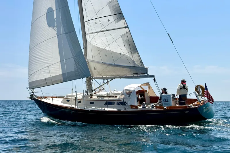 Slide: The Image of Vintage 1970 Hincley 38 sailboat cruising on open sea under clear skies. - 4