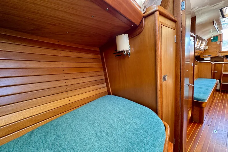 Slide: The Image of 1970 Hincley 38 yacht interior with wooden paneling and teal cushions. - 34