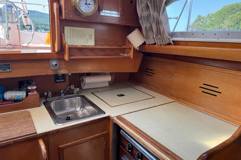 Slide: The Image of 1970 Hincley 38 yacht interior with wooden cabinetry, sink, and nautical decor. - 20