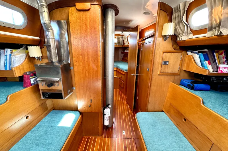 Slide: The Image of Interior of a 1970 Hincley 38 sailboat with wooden furnishings and cozy seating. - 26