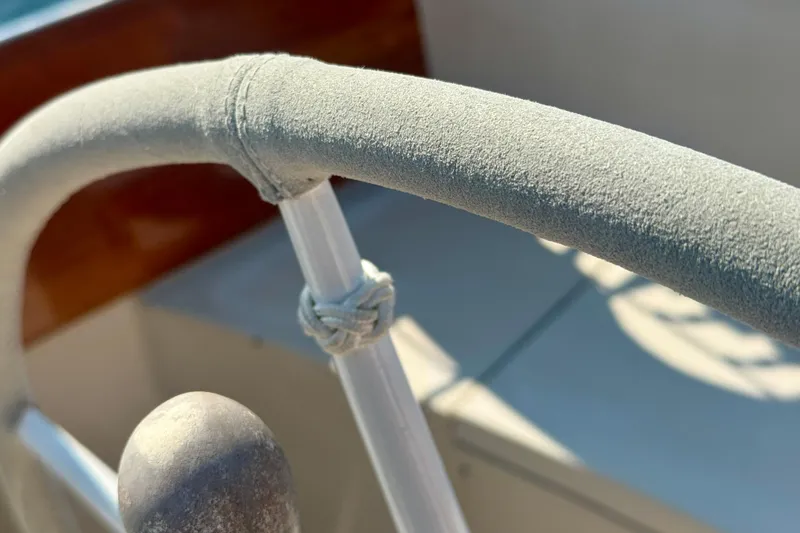 Slide: The Image of Close-up of a 1970 Hincley 38 boat's steering wheel with textured grip and knot detail. - 12