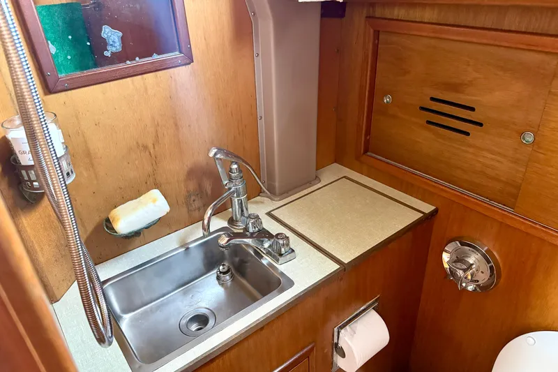 Slide: The Image of 1970 Hincley 38 yacht interior with wooden cabinetry and compact sink area. - 29