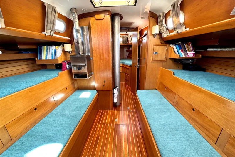 Slide: The Image of Interior of a 1970 Hincley 38 sailboat with wooden furnishings and blue cushions. - 27