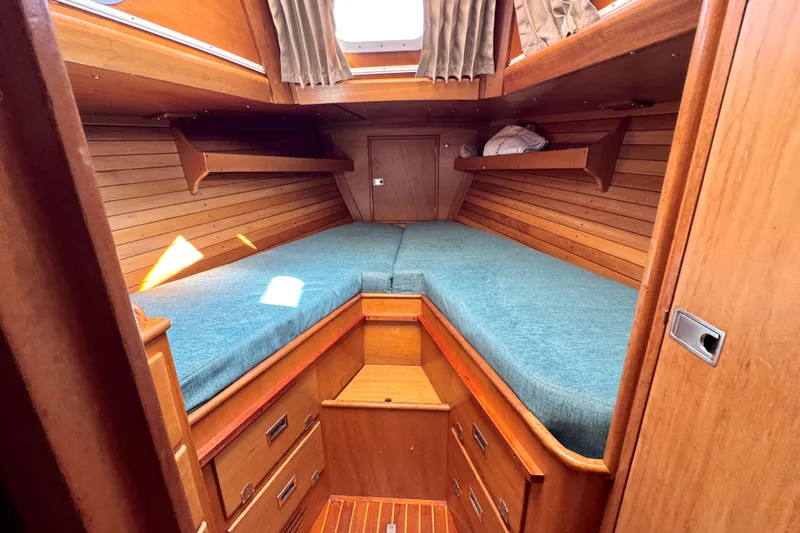 Slide: The Image of Cozy cabin interior of a 1970 Hincley 38 sailboat with wooden finish and teal bedding. - 32