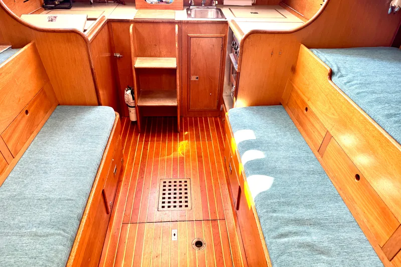 Slide: The Image of Interior of a 1970 Hincley 38 sailboat with wooden finish and blue cushions. - 24