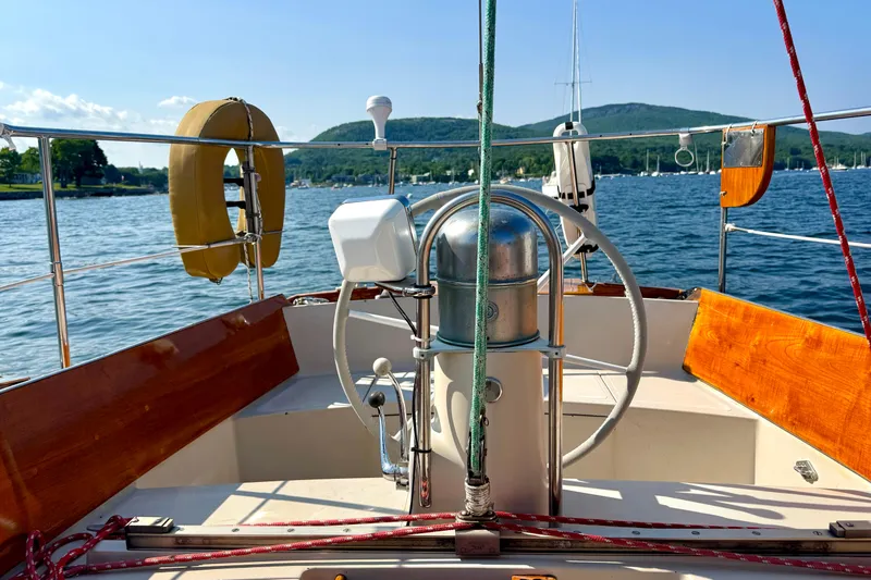 Slide: The Image of Vintage 1970 Hincley 38 sailboat cockpit with scenic lake and mountain backdrop. - 11