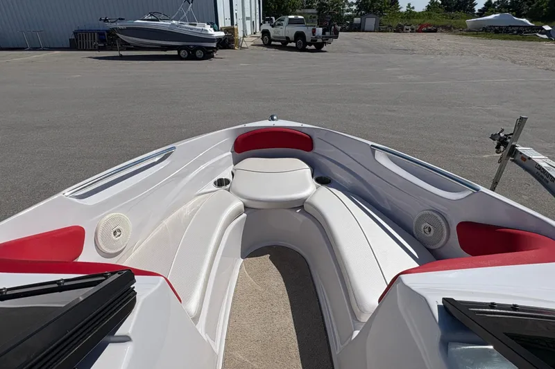 Slide: The Image of 2011 Four Winns H190SS boat interior with red and white seating, parked outdoors. - 14