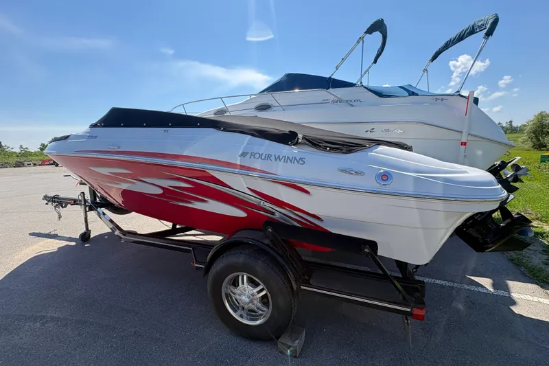 Slide: The Image of 2011 Four Winns H190SS boat with red and white design on a trailer. - 1