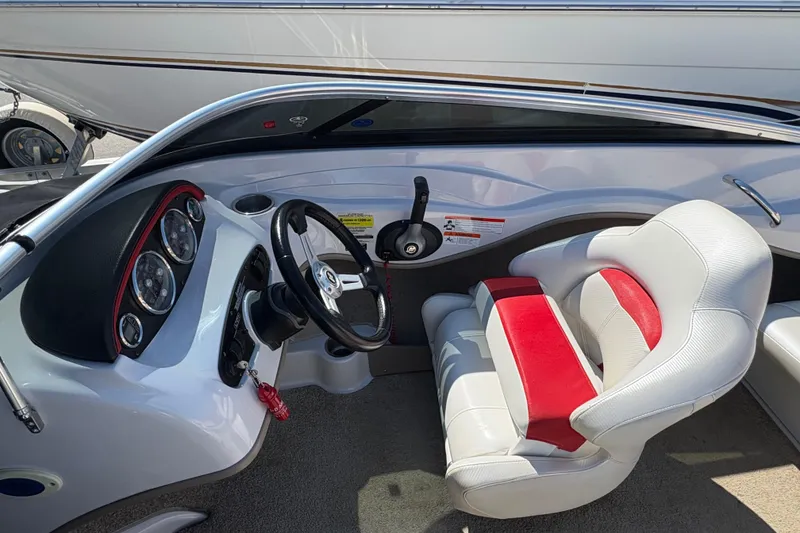 Slide: The Image of 2011 Four Winns H190SS boat interior with steering wheel and red-accented seating. - 5