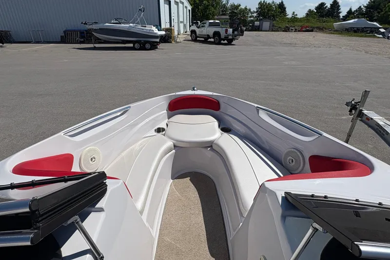 Slide: The Image of 2011 Four Winns H190SS boat interior with red and white seating, parked outdoors. - 15