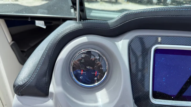 Slide: The Image of Close-up of a boat instrument showing temperature and voltage, surrounded by a padded dashboard. - 25