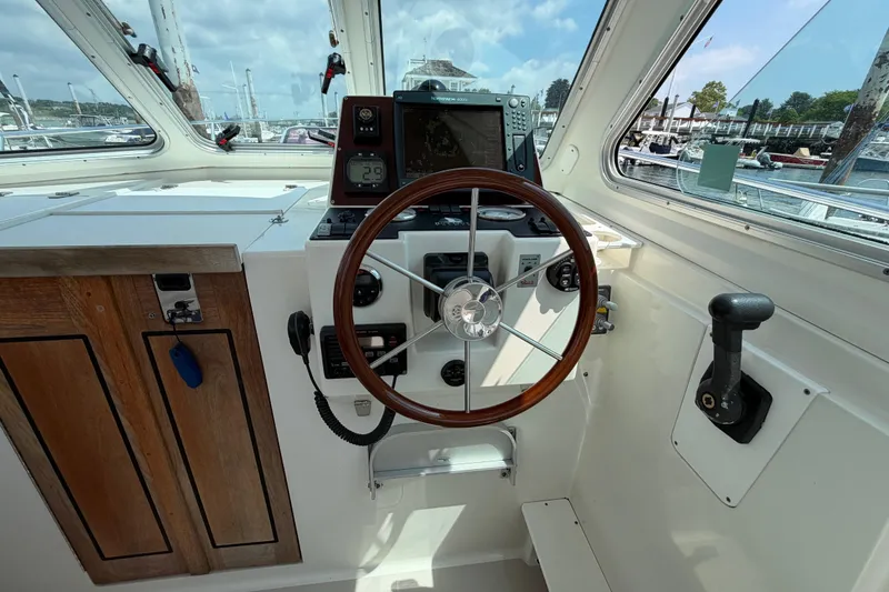 Slide: The Image of 2006 Back Cove 29 boat helm with wooden steering wheel and navigation equipment. - 18
