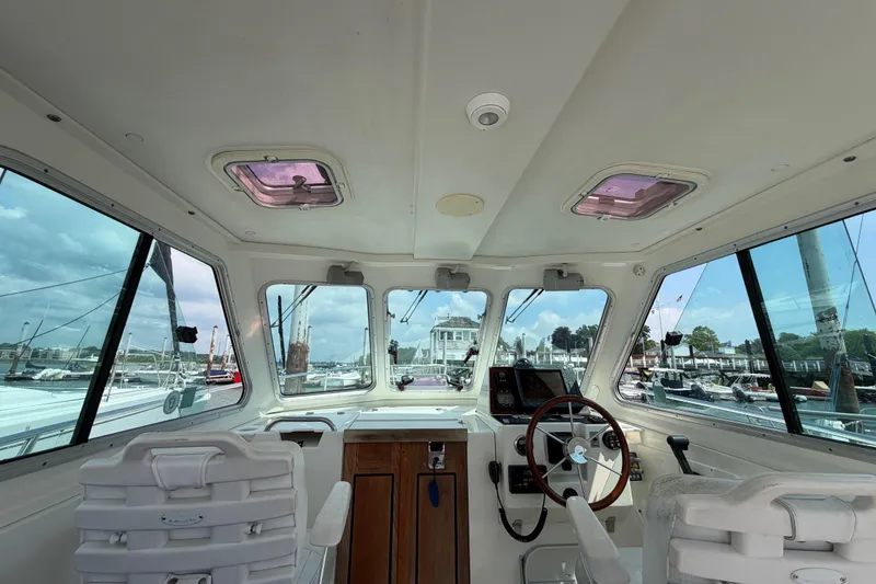 Slide: The Image of Interior view of a 2006 Back Cove 29 boat, showcasing helm and seating area. - 16