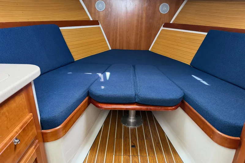 Slide: The Image of Interior of 2006 Back Cove 29 boat with blue cushioned seating and wooden accents. - 27