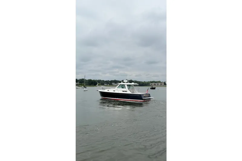 Slide: The Image of 2006 Back Cove 29 boat cruising on a calm, overcast waterway. - 7