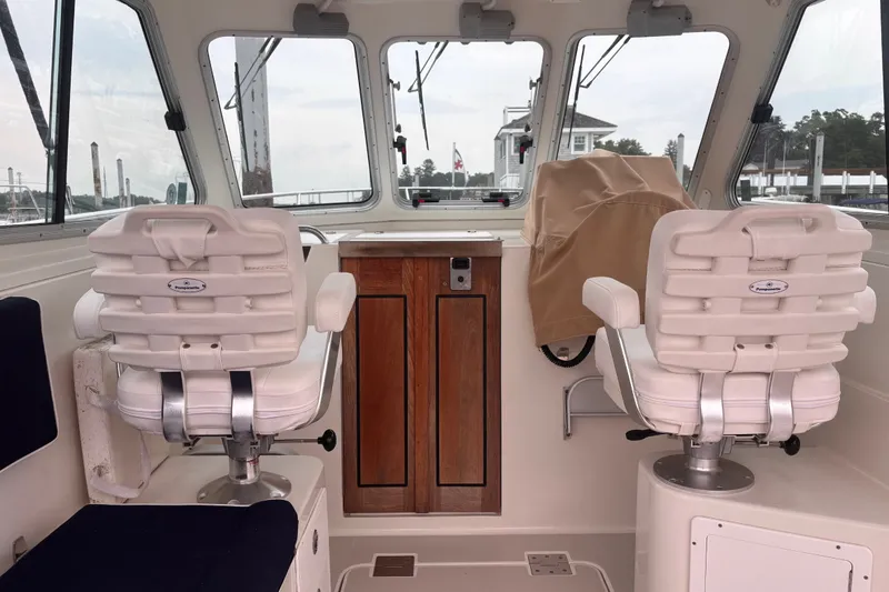 Slide: The Image of Interior of a 2006 Back Cove 29 boat with two white captain chairs. - 14