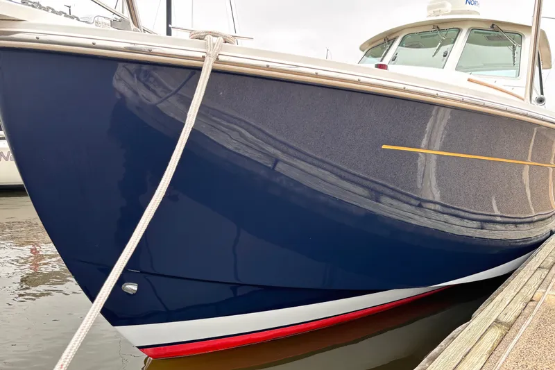 Slide: The Image of 2006 Back Cove 29 boat docked, featuring a sleek blue hull and white trim. - 3