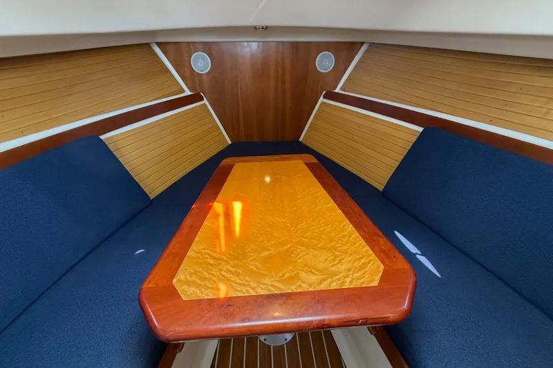 Slide: The Image of Interior of 2006 Back Cove 29 boat with wooden table and blue seating. - 26