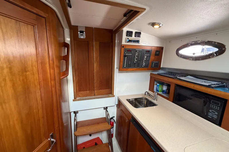 Slide: The Image of 2006 Back Cove 29 interior with kitchenette, sink, microwave, and control panel. - 24